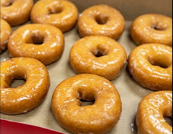 Yellow glazed donuts arranged neatly in a donut box