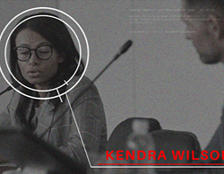 A stillframe from the final video portraying a woman in a meeting with more graphics, also revealing cast member names